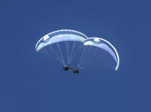 Two paragliders doing air acrobatics stock photo Two paragliders doing air acrobatics stock photo