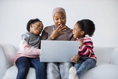 Sisters with mother watching cartoons on laptop in studio