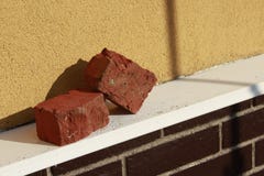 Two red bricks on brick wall`s ledge royalty free stock photography Two red bricks on brick wall`s ledge royalty free stock photography