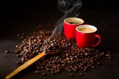 Two Red Cups Of Espresso With Coffee Beans On Dark Wooden Background. Royalty Free Stock Photography Two Red Cups Of Espresso With Coffee Beans On Dark Wooden Background. Royalty Free Stock Photography