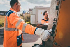 Two refuse collection workers loading garbage into waste truck stock image Two refuse collection workers loading garbage into waste truck stock image