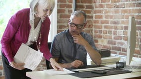 Two Senior Businesspeople Having Meeting In Design Studio