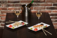 Two sets of sushi rolls with chopsticks and wine glasses royalty free stock photos Two sets of sushi rolls with chopsticks and wine glasses royalty free stock photos