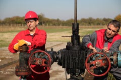Two Skilled Oil and Gas Engineers in Action at Oil Well. stock image Two Skilled Oil and Gas Engineers in Action at Oil Well. stock image