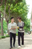 Two smiling young businessmen walking and talking in the city stock images Two smiling young businessmen walking and talking in the city stock images