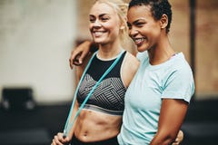 Two smiling young women standing together after working out