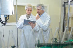 Two specialists in factory checking bottles royalty free stock photo Two specialists in factory checking bottles royalty free stock photo