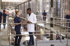 Two staff talking in a modern winemaking factory, close up stock images Two staff talking in a modern winemaking factory, close up stock images