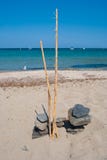 Natural composition of overlapping pebbles and bamboo canes on a sandy beach stock image Natural composition of overlapping pebbles and bamboo canes on a sandy beach stock image