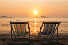 Two sunbeds on the sea beach during sunset. Relax. Stock Photo Two sunbeds on the sea beach during sunset. Relax. Stock Photo