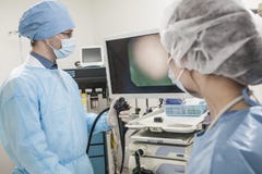 Two surgeons preparing for surgery, looking at medical equipment