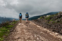 Two tourists hiking along in the mountain road, Turkey royalty free stock photography Two tourists hiking along in the mountain road, Turkey royalty free stock photography