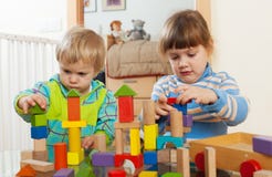 Two tranquil children playing with wooden toys stock photo Two tranquil children playing with wooden toys stock photo
