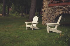 Two White Wooden Lawn Chairs in Grass by Home Royalty Free Stock Images Two White Wooden Lawn Chairs in Grass by Home Royalty Free Stock Images