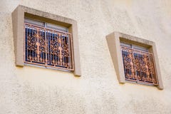 Two Windows with metal bars on the facade of the house close-up royalty free stock photos Two Windows with metal bars on the facade of the house close-up royalty free stock photos