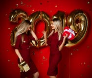 Two women celebrating at new year party happy laughing girls in casual dresses throw gold stars confetti with 2019 balloons stock photos Two women celebrating at new year party happy laughing girls in casual dresses throw gold stars confetti with 2019 balloons stock photos