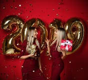 Two women celebrating at new year party happy laughing girls in casual dresses throw gold stars confetti with 2019 balloons stock images Two women celebrating at new year party happy laughing girls in casual dresses throw gold stars confetti with 2019 balloons stock images