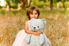 Two-year-old Girl In Field Carrying Stuffed Animal Royalty Free Stock Photo