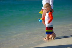 Two year old toddler walking on beach with mother Stock Image Two year old toddler walking on beach with mother Stock Image