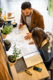 Two young architects looking over building plans during a meeting royalty free stock photography Two young architects looking over building plans during a meeting royalty free stock photography