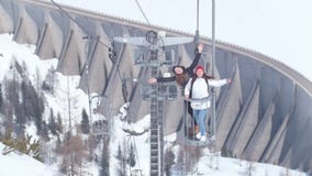 Two young excited women traveling in Dolomites. Lifting on a funicular stock footage Two young excited women traveling in Dolomites. Lifting on a funicular stock footage