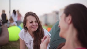 Two young happy brunette girls talking at the park.Beautiful friends smiling and laughing in summer day. stock video Two young happy brunette girls talking at the park.Beautiful friends smiling and laughing in summer day. stock video