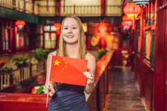 Tycka om semester i Kina Ung kvinna med en kinesisk flagga på en kinesisk bakgrund Lopp till det Kina begreppet VISAEN frigör arkivbilder Tycka om semester i Kina Ung kvinna med en kinesisk flagga på en kinesisk bakgrund Lopp till det Kina begreppet VISAEN frigör arkivbilder