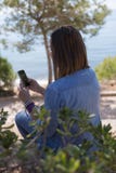 Tylny widok kobiety mienia telefon zdjęcie stock Tylny widok kobiety mienia telefon zdjęcie stock