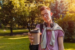Type beau d'université refroidissant au printemps le parc de campus Café potable d'étudiant heureux d'homme photos libres de droits Type beau d'université refroidissant au printemps le parc de campus Café potable d'étudiant heureux d'homme photos libres de droits