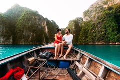 Type et fille voyageant en bateau autour des îles image libre de droits Type et fille voyageant en bateau autour des îles image libre de droits