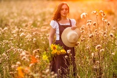 Type rustique Fille avec des tournesols dans le domaine photos stock Type rustique Fille avec des tournesols dans le domaine photos stock