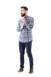 Type sûr barbu frais obtenant habillé boutonnant le bouton de douille et regardant loin pensivement photo stock Type sûr barbu frais obtenant habillé boutonnant le bouton de douille et regardant loin pensivement photo stock