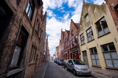 Typisk gammal smal stenlagd gata med traditionella tegelstenhus i Bruges arkivbilder Typisk gammal smal stenlagd gata med traditionella tegelstenhus i Bruges arkivbilder