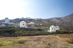 Typisk väderkvarn i Santorini Vita byggnader på en kulle, en väderkvarn och träd, är typiska för Santorini, Grekland Berömda väde fotografering för bildbyråer Typisk väderkvarn i Santorini Vita byggnader på en kulle, en väderkvarn och träd, är typiska för Santorini, Grekland Berömda väde fotografering för bildbyråer