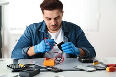 Técnico que comprueba smartphone quebrado en el taller de reparaciones imagenes de archivo Técnico que comprueba smartphone quebrado en el taller de reparaciones imagenes de archivo