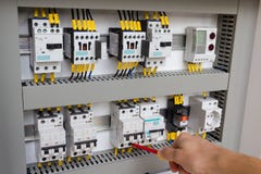 Técnico que trabalha no gabinete elétrico