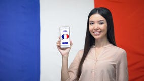 Téléphone de participation de fille avec apprendre l'application française, drapeau sur le fond, éducation banque de vidéos Téléphone de participation de fille avec apprendre l'application française, drapeau sur le fond, éducation banque de vidéos