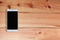 Téléphone portable ou Smartphone avec l'écran vide sur le plancher en bois, vue supérieure images libres de droits Téléphone portable ou Smartphone avec l'écran vide sur le plancher en bois, vue supérieure images libres de droits