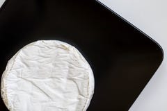 Tête de fromage de camembert ou de brie dans le plat de place noire, minimalisme Vue supérieure, l'espace de copie Images libres de droits Tête de fromage de camembert ou de brie dans le plat de place noire, minimalisme Vue supérieure, l'espace de copie Images libres de droits