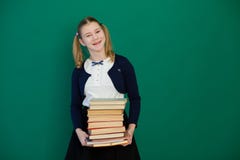 Uczennicy dziewczyna podczas lekcji przy Blackboard z książkami zdjęcia royalty free Uczennicy dziewczyna podczas lekcji przy Blackboard z książkami zdjęcia royalty free