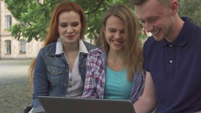 Uhr der jungen Leute etwas auf Laptop auf dem Campus lizenzfreies stockfoto Uhr der jungen Leute etwas auf Laptop auf dem Campus lizenzfreies stockfoto