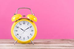 Uhrwarnung auf hölzernem Schreibtisch und rosa Weiblichkeitshintergrund stockbild Uhrwarnung auf hölzernem Schreibtisch und rosa Weiblichkeitshintergrund stockbild
