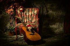 Uitstekende Akoestische Gitaar die tegen Antieke Stoel leunen stock foto Uitstekende Akoestische Gitaar die tegen Antieke Stoel leunen stock foto