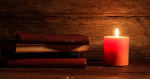Uitstekende boeken en een kaars op houten achtergrond Stock Afbeelding