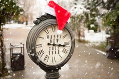 Uitstekende klok met santahoed en woorden Gelukkig Nieuwjaar Stock Afbeeldingen Uitstekende klok met santahoed en woorden Gelukkig Nieuwjaar Stock Afbeeldingen