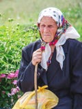 Ukraine. Khmelnitsky region. May 2018.Portrait of an elderly woman with stick in her arms, woman is in trouble_ stock photo Ukraine. Khmelnitsky region. May 2018.Portrait of an elderly woman with stick in her arms, woman is in trouble_ stock photo