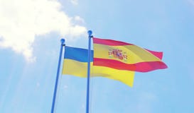ukraine-spain-flags-waving-against-blue-