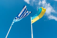 Ukrainische Flagge mit griechischer Flagge auf Hintergrund des Himmels stockbilder Ukrainische Flagge mit griechischer Flagge auf Hintergrund des Himmels stockbilder