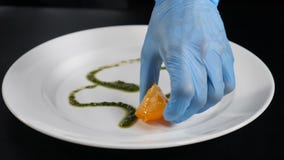 Ultrarapidfoodvideobegrepp Stäng sig upp av kocken som drar med karamellsirap på en vit platta F?rbereda sig f?r sallad fine arkivfilmer Ultrarapidfoodvideobegrepp Stäng sig upp av kocken som drar med karamellsirap på en vit platta F?rbereda sig f?r sallad fine arkivfilmer