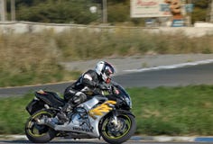 Ulyanovsk, Russia - August 19, 2017. A Motorcycle Racer With A Backpack Trains On A Motorcycle On A Sports Track. Motion Stock Photos Ulyanovsk, Russia - August 19, 2017. A Motorcycle Racer With A Backpack Trains On A Motorcycle On A Sports Track. Motion Stock Photos